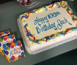 A cake that says "Happy 100th Birthday Jack"