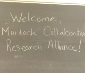 A chalkboard with "Welcome, Murdock Collaborative Research Alliance" written on it. 