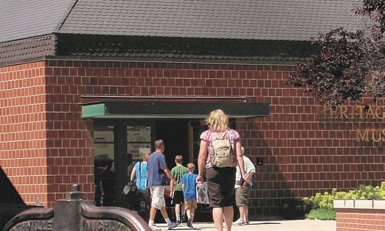 A brick building with children and adults walking into it. 