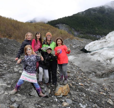 A group of five girls pose on a rocky hill