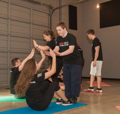 A group of young people perform exercises together.