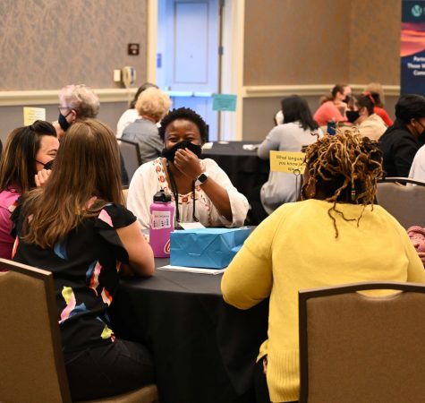 A group of women gather around a table at the Women in Leadership Conference.