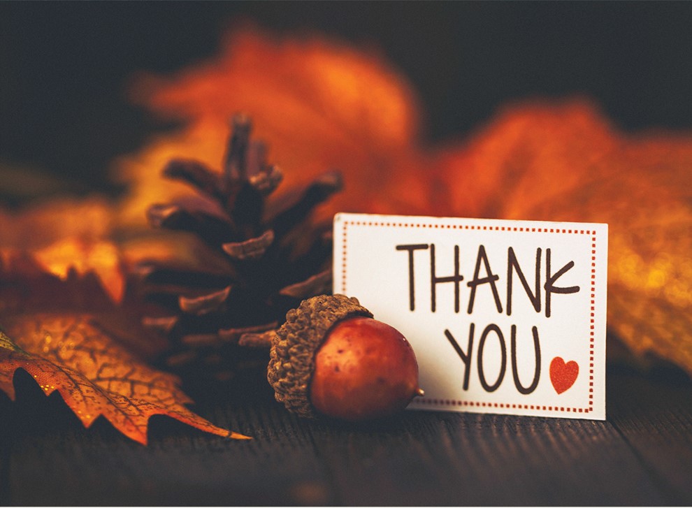 A card that says "Thank You" next to an acorn and some fall leaves, to honor this season of giving thanks