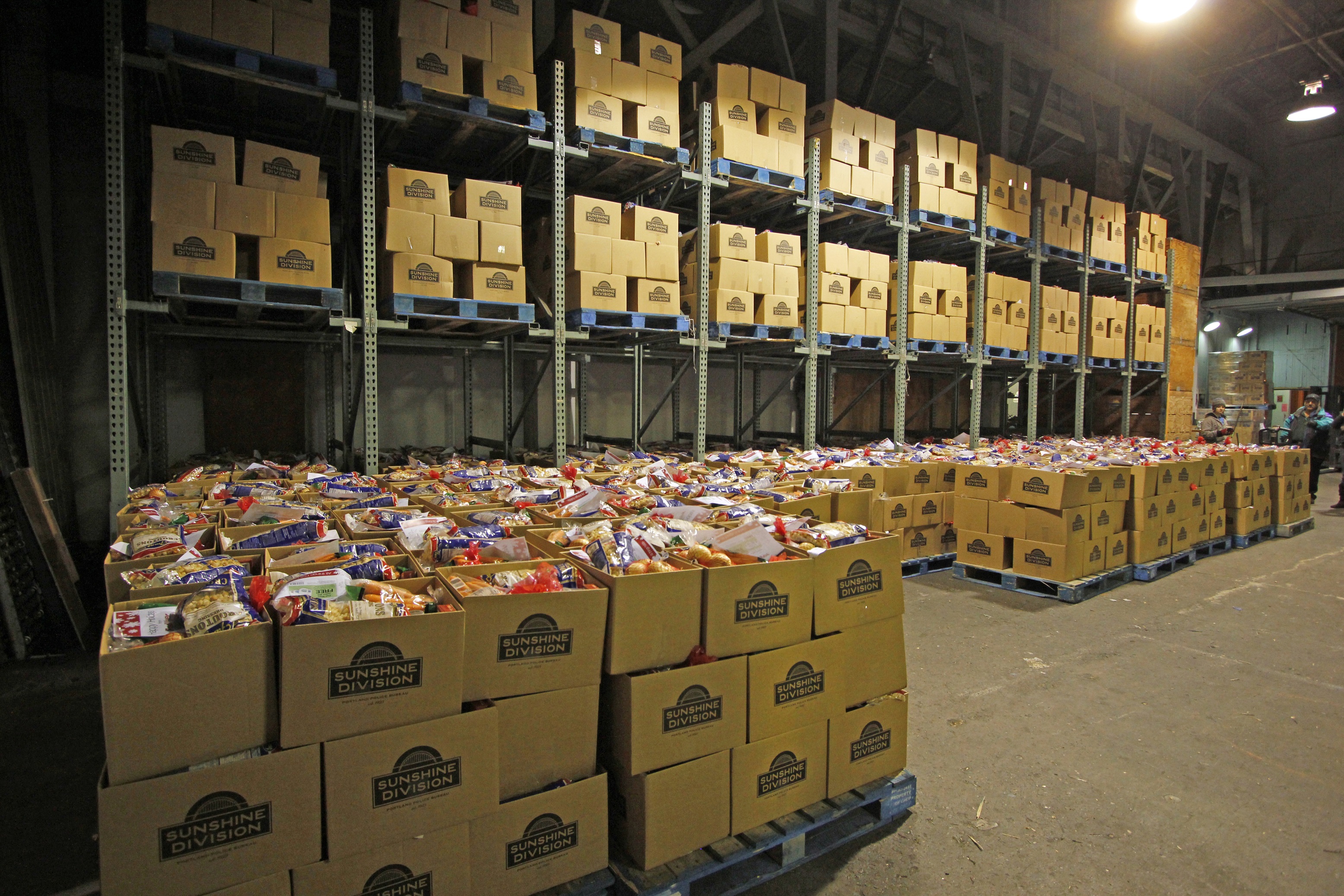 A warehouse full of boxes that say "Sunshine Division" loaded with food