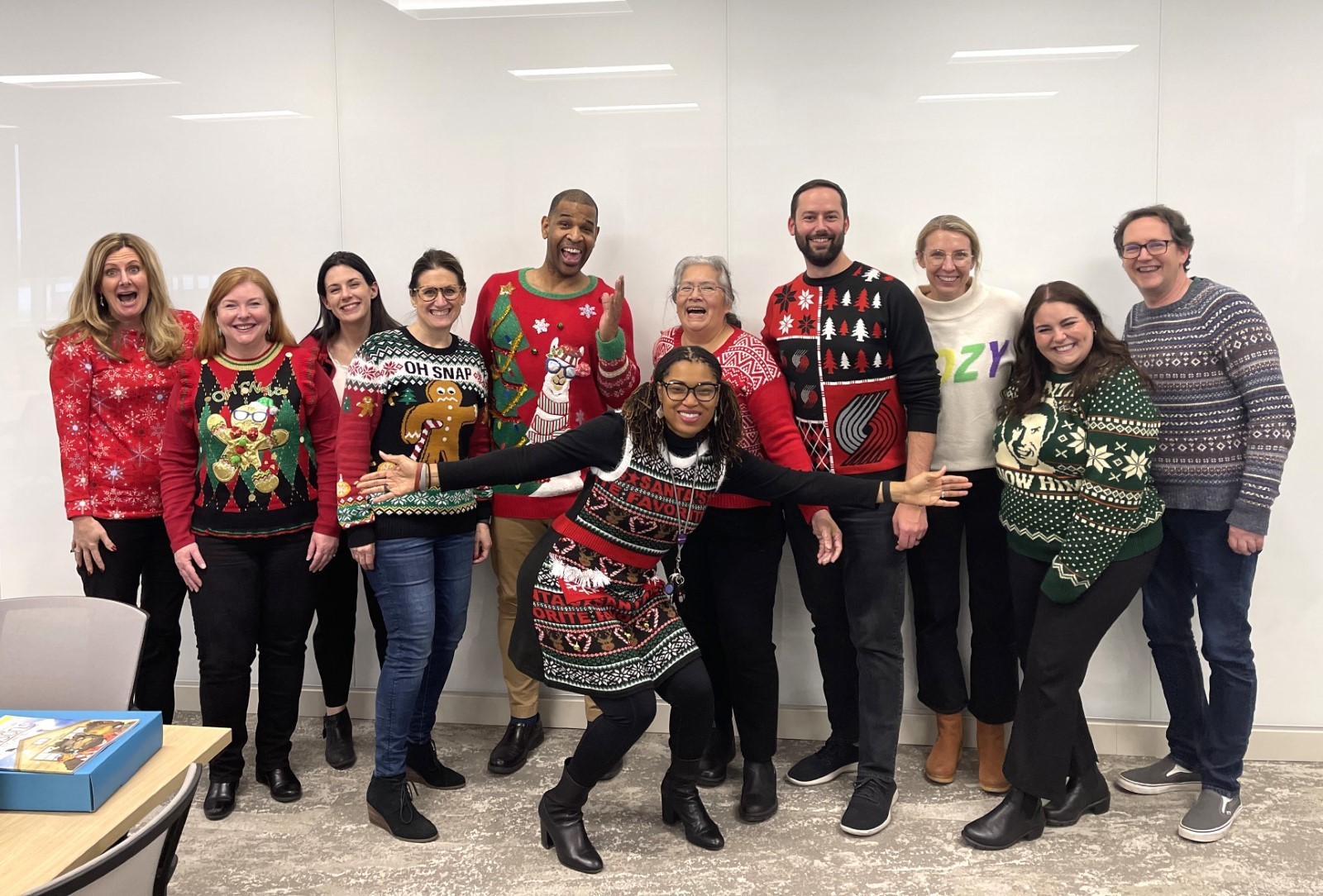 Group of 11 Murdock Trust employees wearing fun holiday sweaters and smiling together