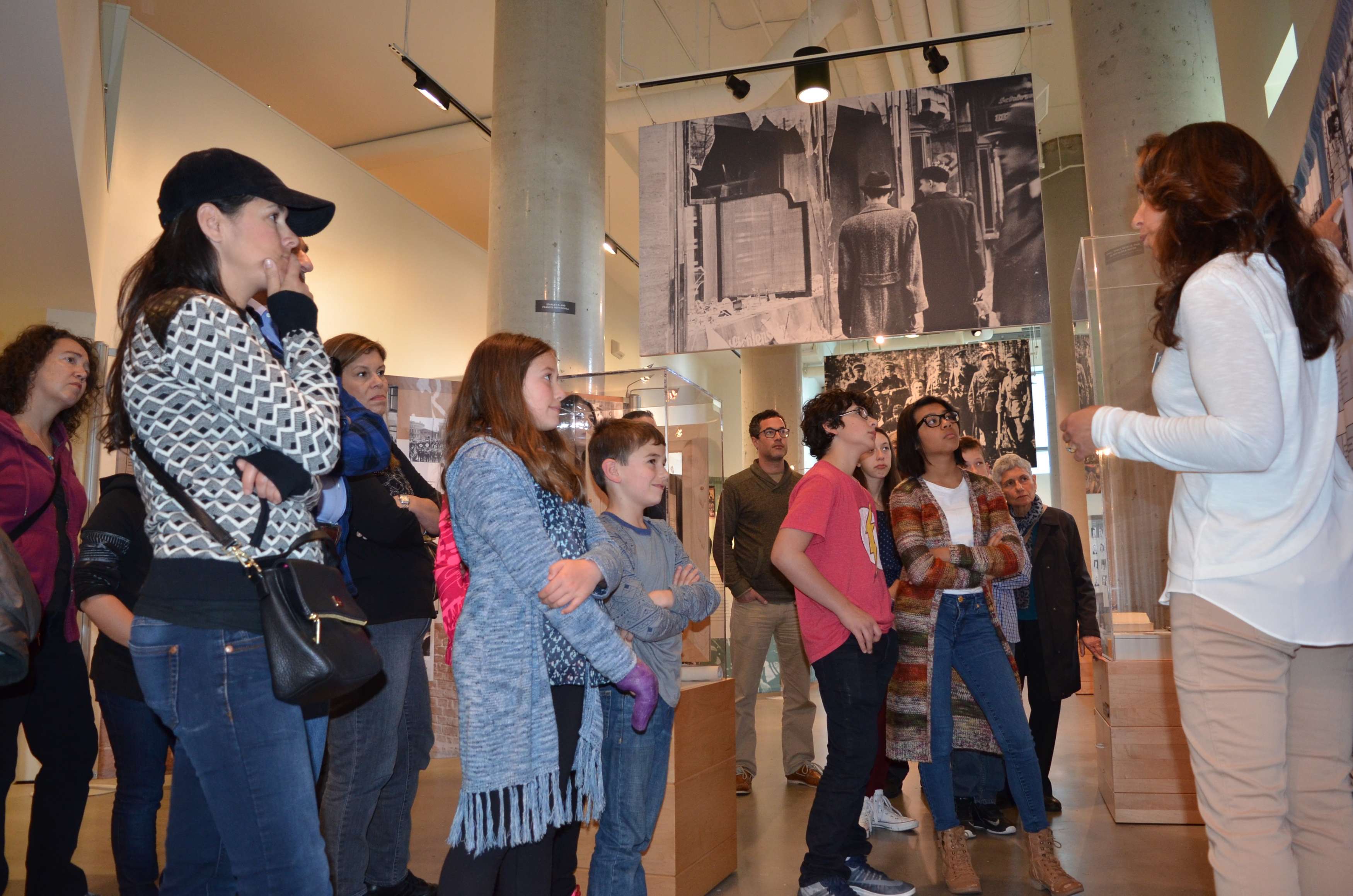 Museum docent leading group of visitors on a tour of the Holocaust Center for Humanity exhibit