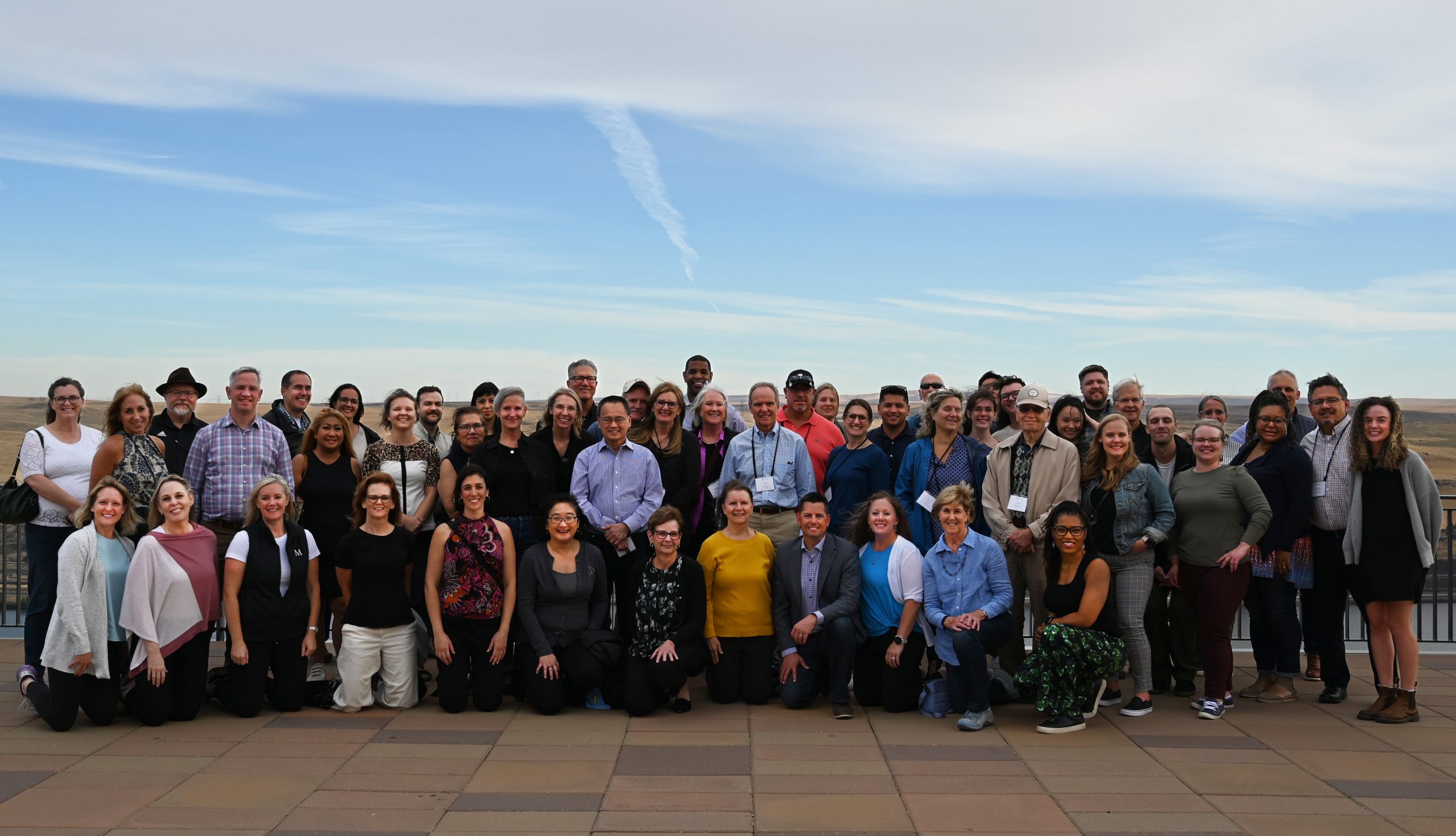 Group of people standing and kneeling against a blue sky