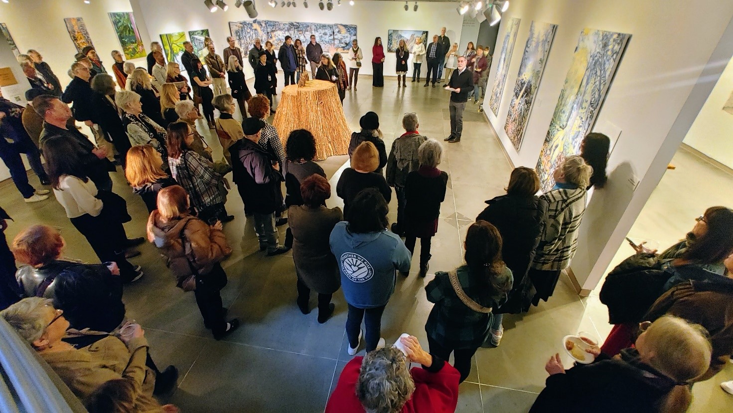 Group of people in an art museum, listening to one person speak