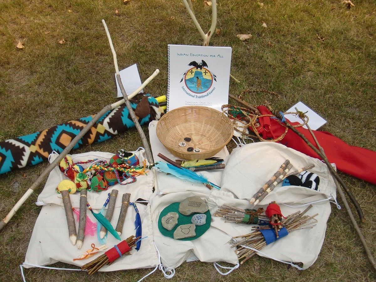 Group of baskets, leaves, and sticks on grassy ground