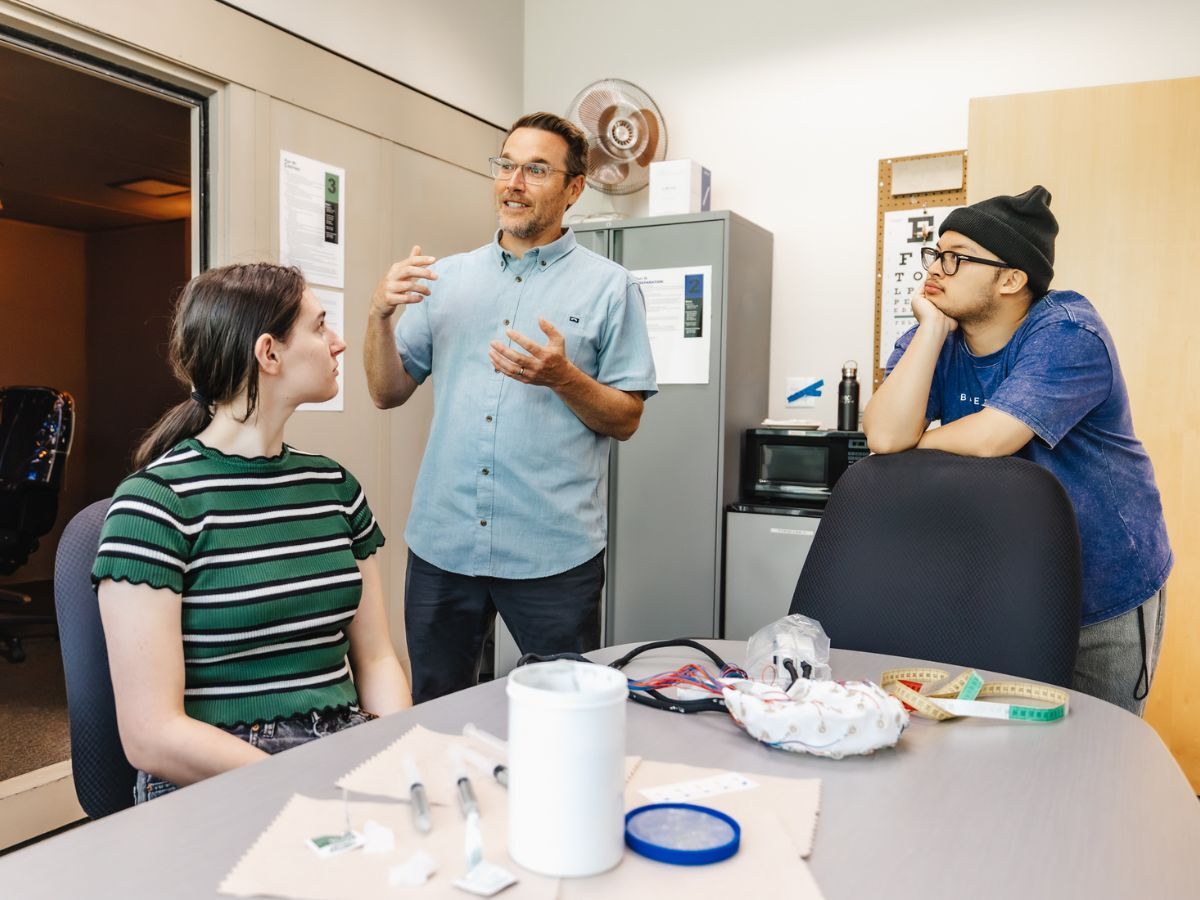 Michael Pitts, professor of psychology at Reed College, explaining something to two students before an experiment.