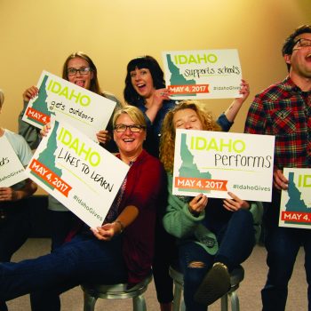 A group of people hold signs that say "Idaho Performs," "Idaho Likes to Learn," "Idaho Gets Outdoors," and more