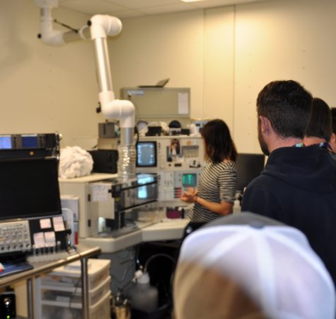 A group of adults tours a science lab.