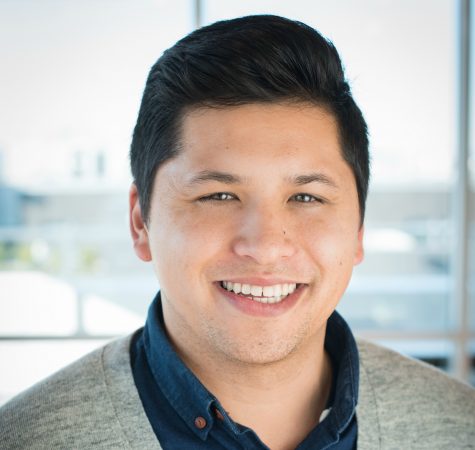 A man with black hair smiling at the camera.