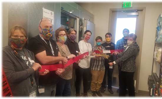 Nine people wearing masks hold a red banner.