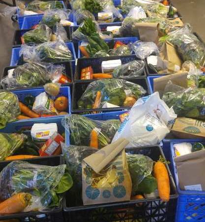 Boxes of vegetables and other food on a table.