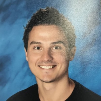 A young man with dark hair smiles for the camera.