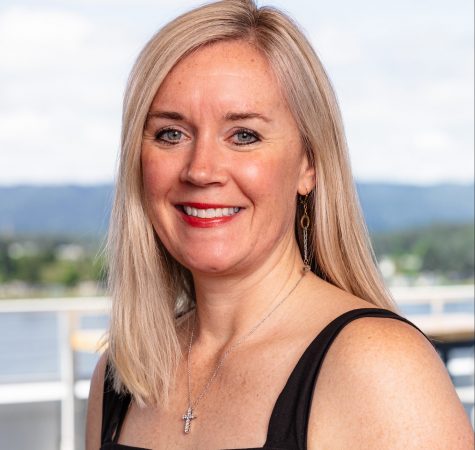 A woman with straight blond hair smiles for the camera