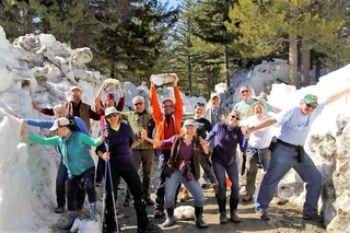Group of teachers staying at Holden Village on a walk between snow piles on a sunny day