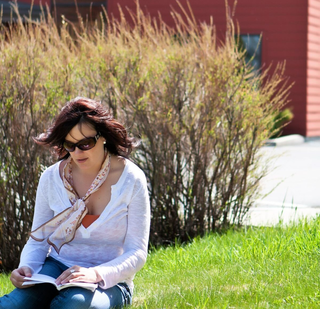 Person reading outside Monastery of St. Gertrude on a sunny day