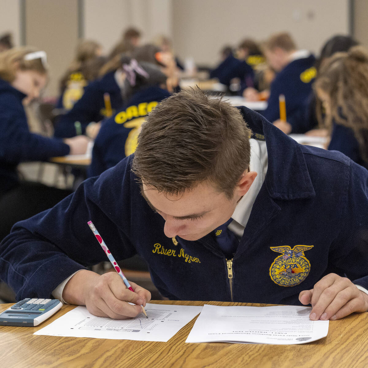 Student in the Future Farmers of America program writing on a piece of paper at a table